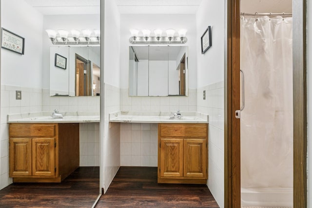 3300 Louisiana Ave S Unit 122, Saint Louis Park, MN 55426 - full bathroom featuring tile walls, a wainscoted wall, wood finished floors, two vanities, and a shower with curtain