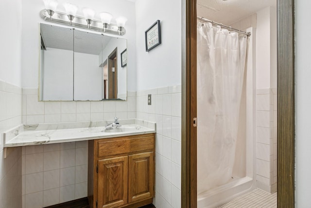3300 Louisiana Ave S Unit 122, Saint Louis Park, MN 55426 - bathroom with vanity, tile walls, a shower stall, wainscoting, and tile patterned floors