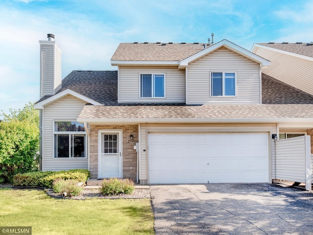 7730 79th St S, Cottage Grove, MN 55016 - view of front facade featuring driveway, roof with shingles, an attached garage, and a front lawn