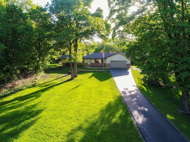 8048 Lake Ida Way NW, Alexandria, MN 56308 - view of front of property featuring stone siding, a chimney, a front lawn, asphalt driveway, and a garage