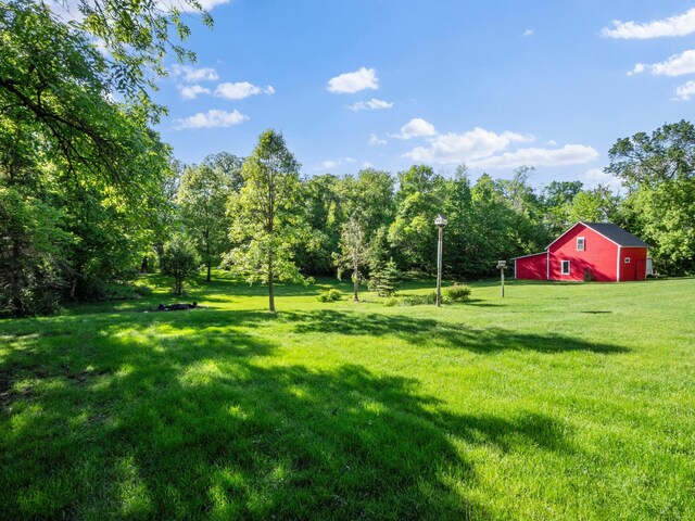 8048 Lake Ida Way NW, Alexandria, MN 56308 - view of grassy yard featuring an outbuilding and view of wooded area