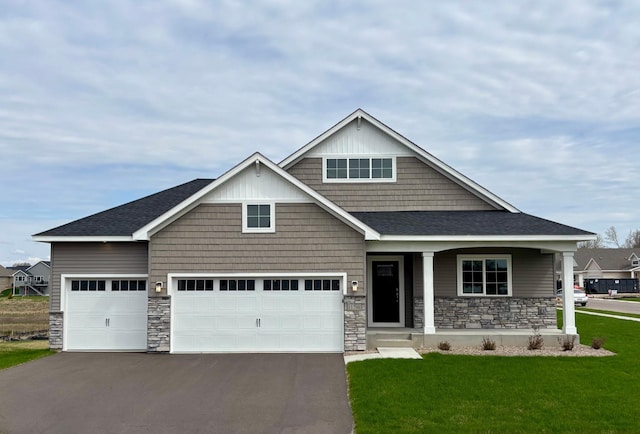 11798 5th St NE, Hanover, MN 55341 - craftsman house featuring stone siding, asphalt driveway, a front lawn, covered porch, and an attached garage