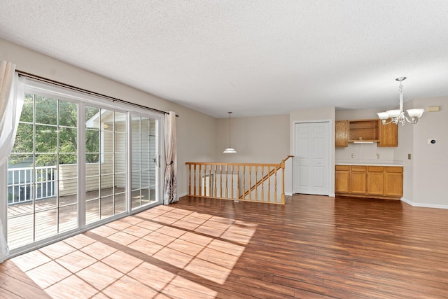 7719 Nicholas Way, Chanhassen, MN 55317 - unfurnished room with a chandelier, a textured ceiling, wood finished floors, and baseboards
