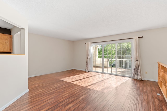 7719 Nicholas Way, Chanhassen, MN 55317 - spare room featuring wood finished floors, baseboards, and a textured ceiling