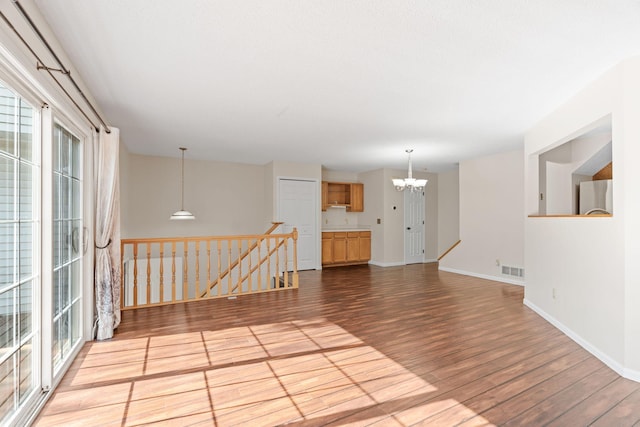 7719 Nicholas Way, Chanhassen, MN 55317 - unfurnished room featuring a chandelier, wood finished floors, and baseboards
