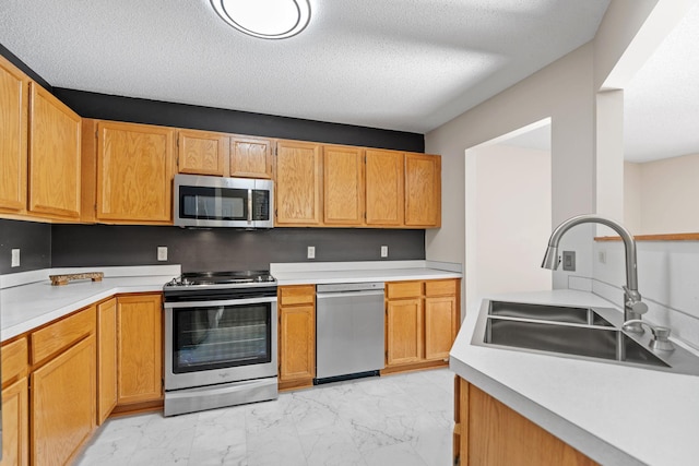 7719 Nicholas Way, Chanhassen, MN 55317 - kitchen with stainless steel appliances, a sink, light marble finish flooring, light countertops, and a textured ceiling