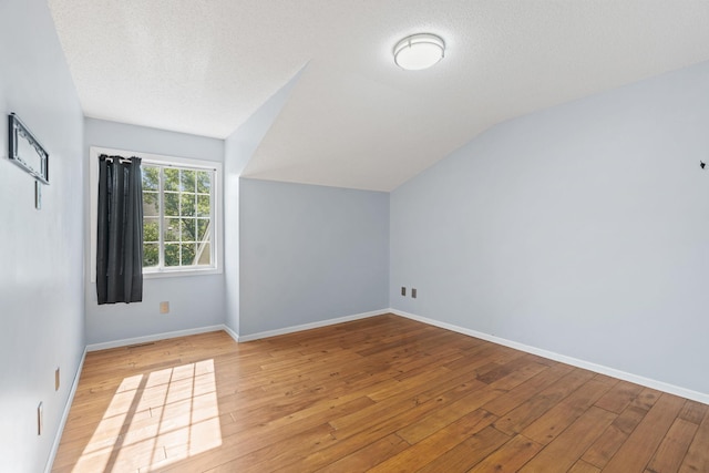 7719 Nicholas Way, Chanhassen, MN 55317 - bonus room featuring light wood-style floors, vaulted ceiling, baseboards, and a textured ceiling