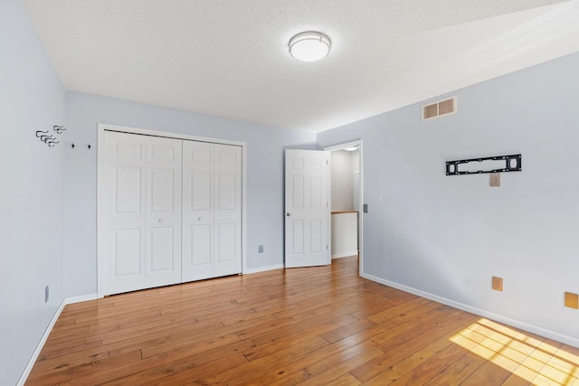 7719 Nicholas Way, Chanhassen, MN 55317 - unfurnished bedroom featuring baseboards, light wood-type flooring, and a closet