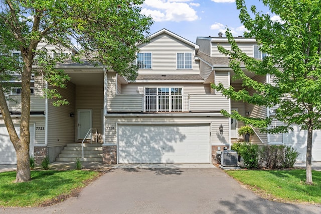 7719 Nicholas Way, Chanhassen, MN 55317 - townhome / multi-family property with asphalt driveway, an attached garage, roof with shingles, and central air condition unit