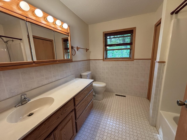 23759 Clarissa Haven Dr, Girard Twp, MN 56551 - full bathroom with tile walls, toilet, wainscoting, vanity, and  shower combination