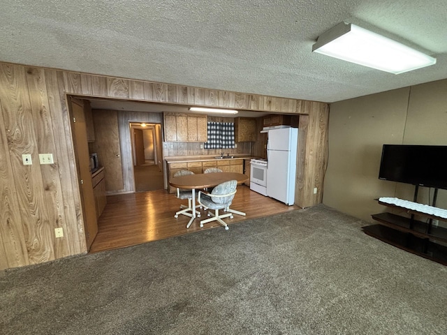 23759 Clarissa Haven Dr, Girard Twp, MN 56551 - kitchen with white appliances, wood walls, carpet, a textured ceiling, and a sink