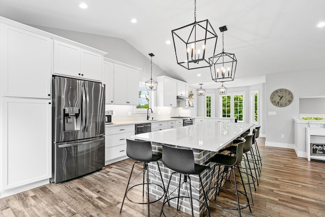 1600 Buffalo Cv, Buffalo, MN 55313 - kitchen with stainless steel appliances, lofted ceiling, light countertops, wood finished floors, and white cabinets