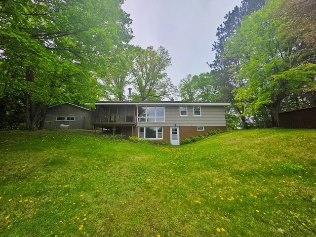 1331 9th St, Grand Rapids, MN 55744 - back of property featuring a sunroom and a lawn