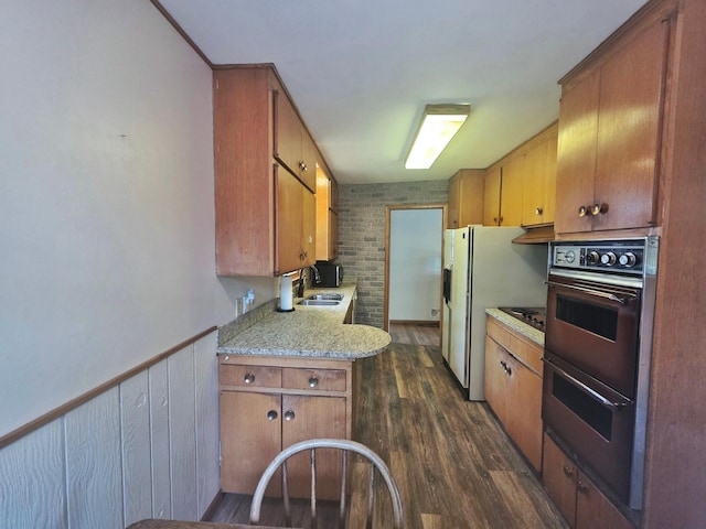 1331 9th St, Grand Rapids, MN 55744 - kitchen featuring light countertops, under cabinet range hood, a sink, dark wood-type flooring, and brown cabinets