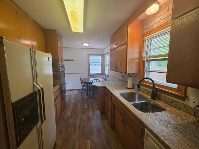 1331 9th St, Grand Rapids, MN 55744 - kitchen with white refrigerator with ice dispenser, a sink, dark wood-type flooring, brown cabinets, and wainscoting