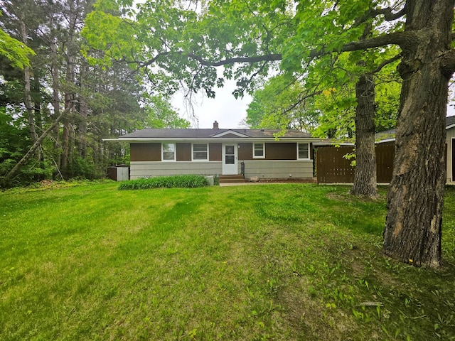1331 9th St, Grand Rapids, MN 55744 - view of front of house with entry steps, a front lawn, and a chimney