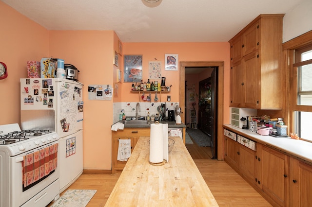 1808 Taylor St NE, Minneapolis, MN 55418 - kitchen featuring butcher block counters, white gas range oven, light wood-type flooring, and backsplash