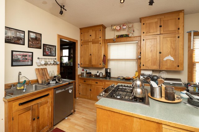 1808 Taylor St NE, Minneapolis, MN 55418 - kitchen featuring stainless steel appliances, light wood-type flooring, a textured ceiling, rail lighting, and brown cabinets