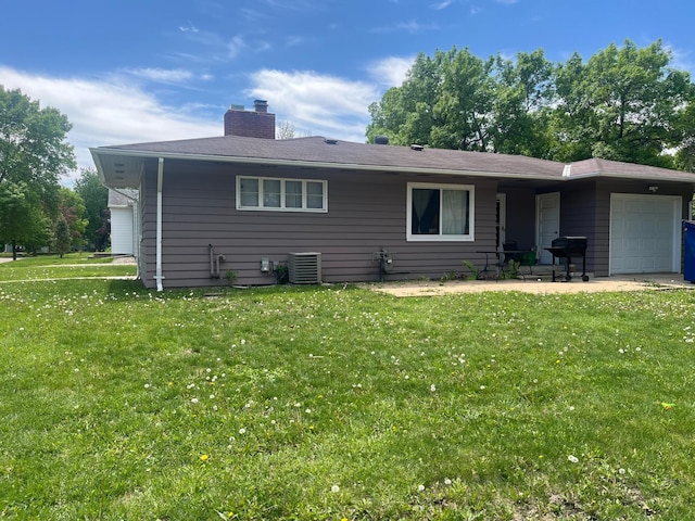 700 14th St SW, Willmar, MN 56201 - rear view of house featuring a garage, cooling unit, a lawn, and a chimney