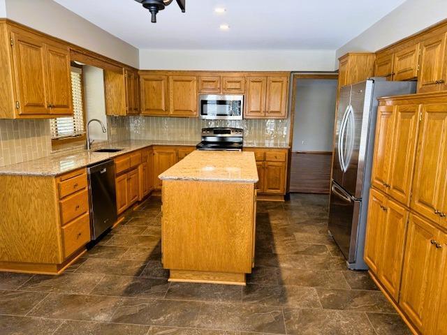 9693 Falcons Way, Eden Prairie, MN 55347 - kitchen with appliances with stainless steel finishes, a sink, a kitchen island, and brown cabinets