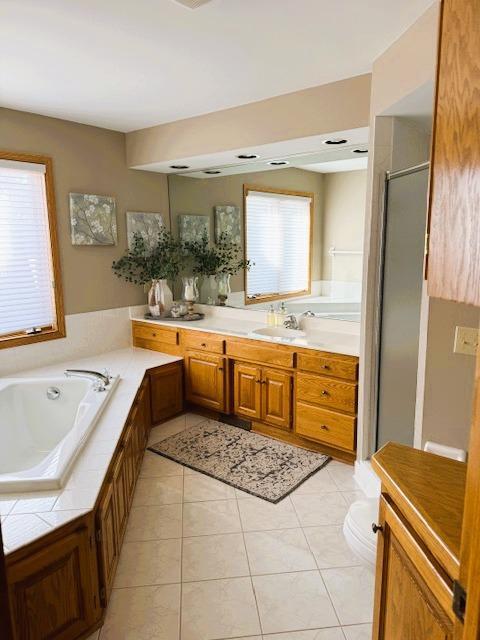 9693 Falcons Way, Eden Prairie, MN 55347 - bathroom featuring a garden tub, tile patterned flooring, toilet, and vanity