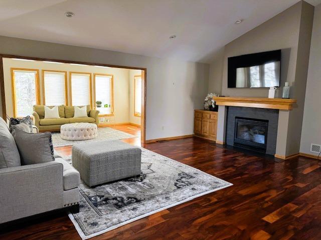 9693 Falcons Way, Eden Prairie, MN 55347 - living area with vaulted ceiling, a glass covered fireplace, baseboards, and dark wood-style flooring