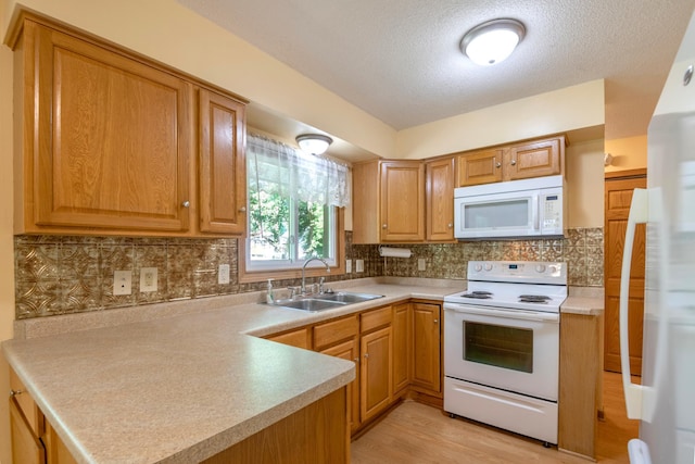 601 4th Ave N, Sauk Rapids, MN 56379 - kitchen with white appliances, light countertops, light wood finished floors, tasteful backsplash, and a peninsula