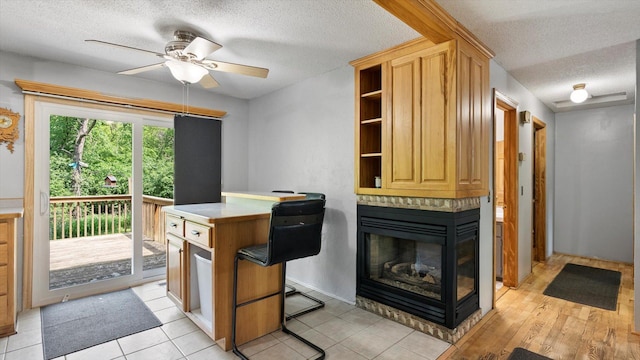 1504 89th Ave N, Brooklyn Park, MN 55444 - kitchen featuring a textured ceiling, a ceiling fan, open shelves, and a multi sided fireplace