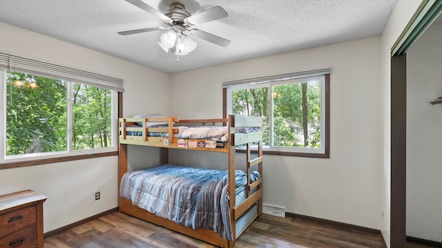 1504 89th Ave N, Brooklyn Park, MN 55444 - bedroom featuring wood finished floors, baseboards, a textured ceiling, and a ceiling fan