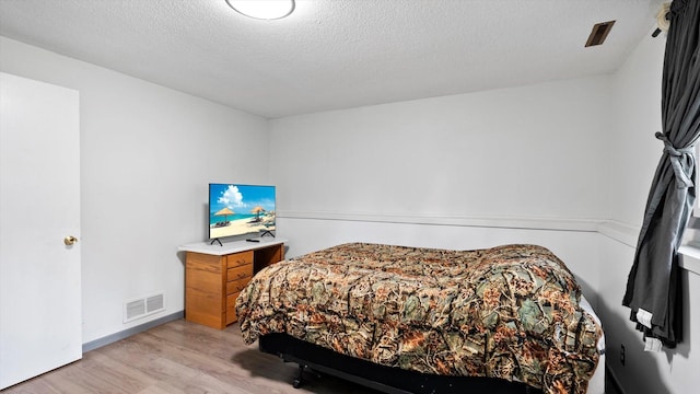 1504 89th Ave N, Brooklyn Park, MN 55444 - bedroom with light wood finished floors and a textured ceiling