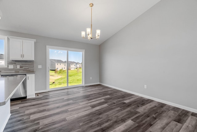 1020 2nd St NW, Delano, MN 55328 - unfurnished dining area featuring a chandelier, dark wood-style flooring, baseboards, and vaulted ceiling