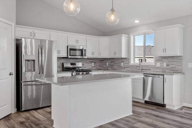 1020 2nd St NW, Delano, MN 55328 - kitchen with stainless steel appliances, a sink, tasteful backsplash, vaulted ceiling, and white cabinetry