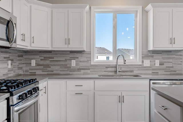 1020 2nd St NW, Delano, MN 55328 - kitchen with a sink, appliances with stainless steel finishes, white cabinets, decorative backsplash, and light countertops