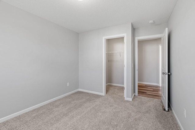 1020 2nd St NW, Delano, MN 55328 - unfurnished bedroom featuring carpet flooring, a closet, baseboards, and a spacious closet