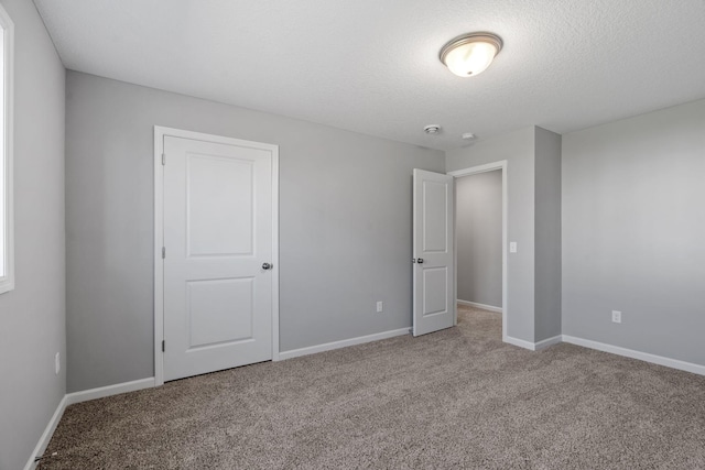 1020 2nd St NW, Delano, MN 55328 - unfurnished bedroom with carpet flooring, baseboards, and a textured ceiling