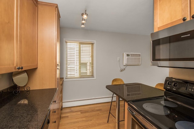 3018 Aldrich Ave S Unit 12, Minneapolis, MN 55408 - kitchen with electric range, stainless steel microwave, a baseboard radiator, a wall mounted air conditioner, and light wood-type flooring