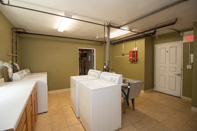 3018 Aldrich Ave S Unit 12, Minneapolis, MN 55408 - laundry room featuring washer and dryer, light tile patterned floors, and baseboards