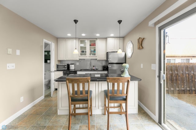 309 12 1/2 Ave E, West Fargo, ND 58078 - kitchen featuring stainless steel appliances, dark countertops, plenty of natural light, a breakfast bar, and recessed lighting