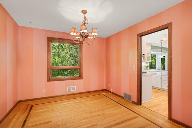 15423 Boulder Creek Dr, Minnetonka, MN 55345 - empty room with light wood-style flooring, plenty of natural light, a chandelier, and baseboards