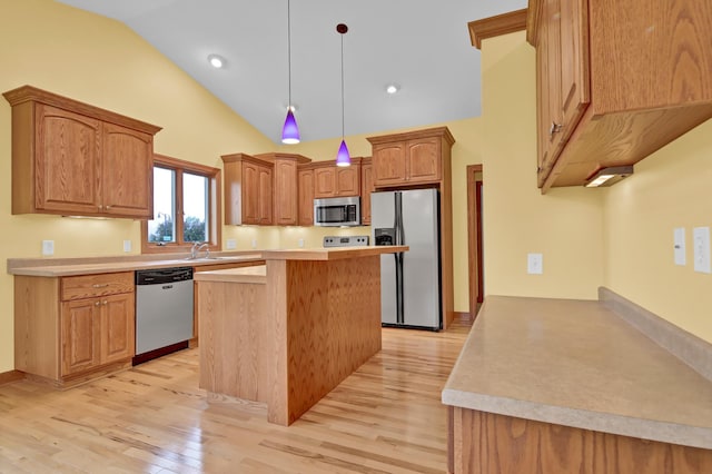 1426 Woodland Way, Lake City, MN 55041 - kitchen with stainless steel appliances, light wood finished floors, light countertops, a kitchen island, and decorative light fixtures
