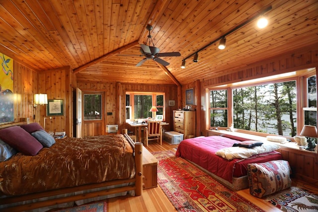X Waters Island, Morse Twp, MN 55731 - bedroom with track lighting, multiple windows, vaulted ceiling, wood finished floors, and wooden walls