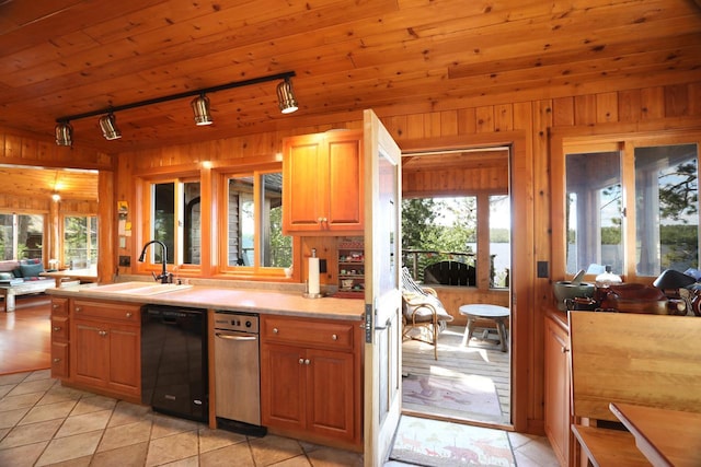 X Waters Island, Morse Twp, MN 55731 - kitchen with black dishwasher, rail lighting, wood walls, light tile patterned floors, and light countertops