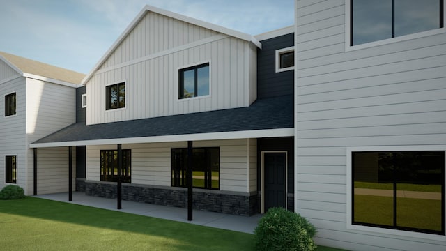 5227 Harvest Square Ln NW, Rochester, MN 55901 - view of front of house featuring board and batten siding, a front yard, a patio, and stone siding