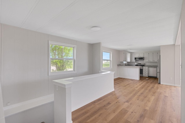 19363 County Road 21, Eden Lake Twp, MN 56368 - kitchen featuring appliances with stainless steel finishes, light wood-type flooring, baseboards, and a peninsula