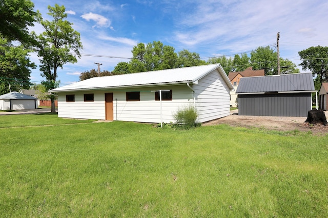411 6th St, Bird Island, MN 55310 - view of front of property featuring a garage, a front lawn, an outbuilding, and metal roof