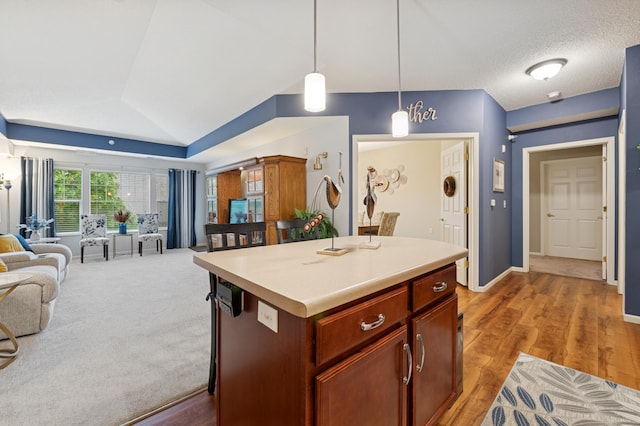 3800 85th Ave N Unit 312, Brooklyn Park, MN 55443 - kitchen featuring open floor plan, hanging light fixtures, light countertops, lofted ceiling, and a kitchen island