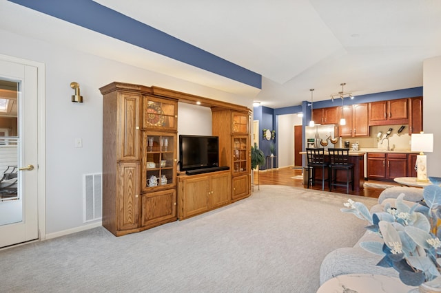 3800 85th Ave N Unit 312, Brooklyn Park, MN 55443 - living area with light carpet, vaulted ceiling, and baseboards
