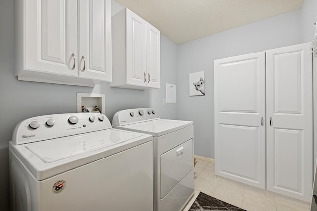 3800 85th Ave N Unit 312, Brooklyn Park, MN 55443 - laundry area featuring independent washer and dryer, cabinet space, light tile patterned floors, and a textured ceiling
