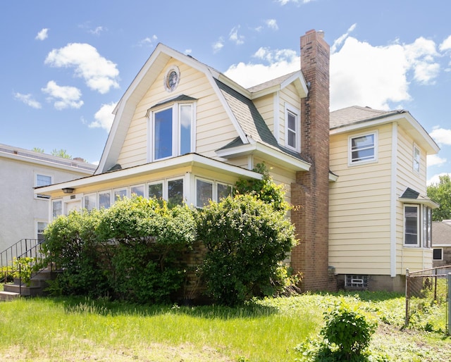 1638 Concordia Ave, Saint Paul, MN 55104 - view of home's exterior featuring a chimney, a gambrel roof, and roof with shingles