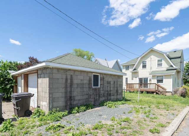 1638 Concordia Ave, Saint Paul, MN 55104 - view of side of property with a shingled roof and a wooden deck
